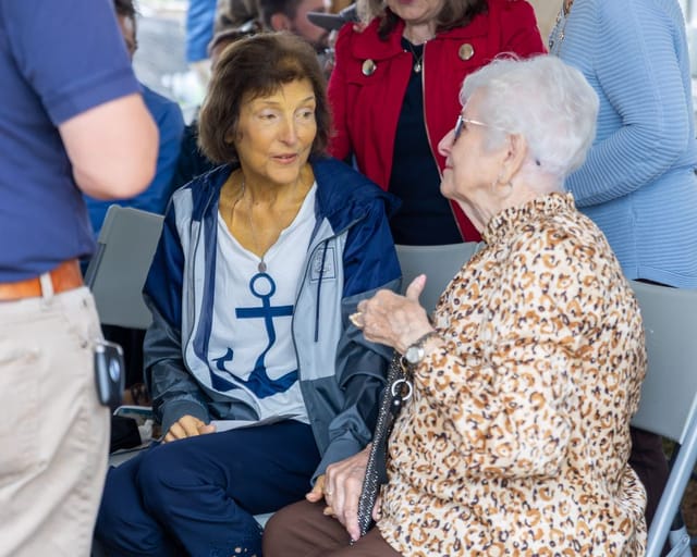 citizens converse under the tent after the ceremony