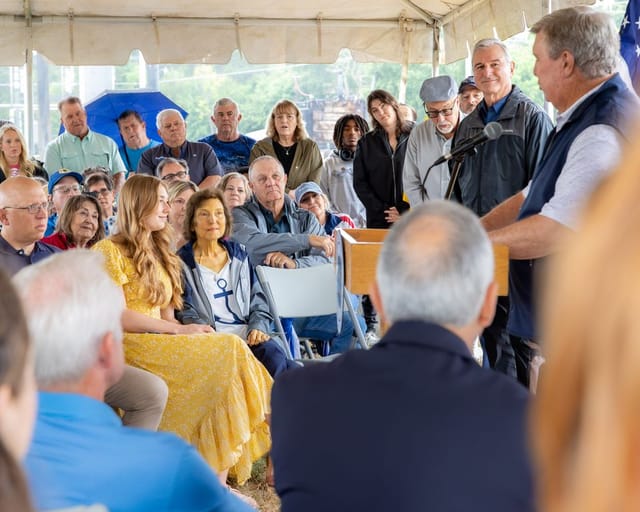 A person speaks at podium and the crowd watches