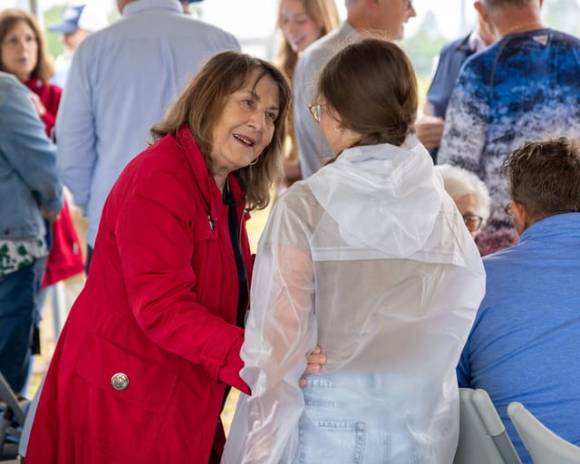 citizens converse under the tent after the ceremony