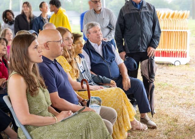 People watch the ceremony under the tent. 