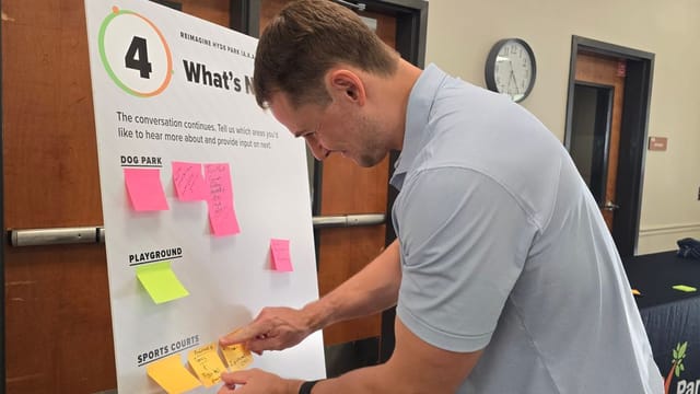 Male posts sticker on community engagement board