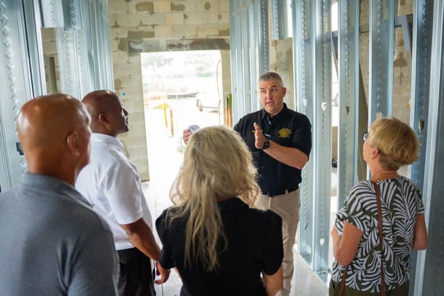 a man talking with a group of people explaining something