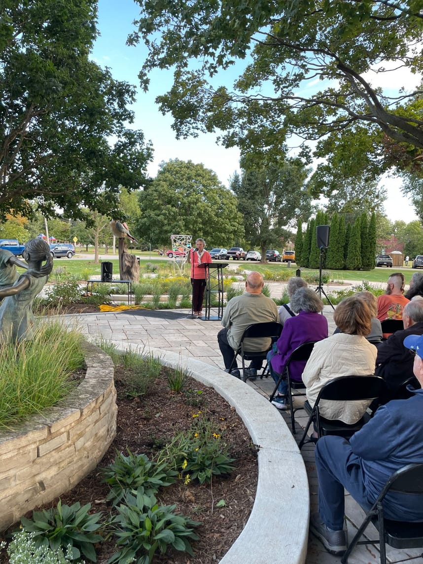A woman speaking into a mic to a crowd of people