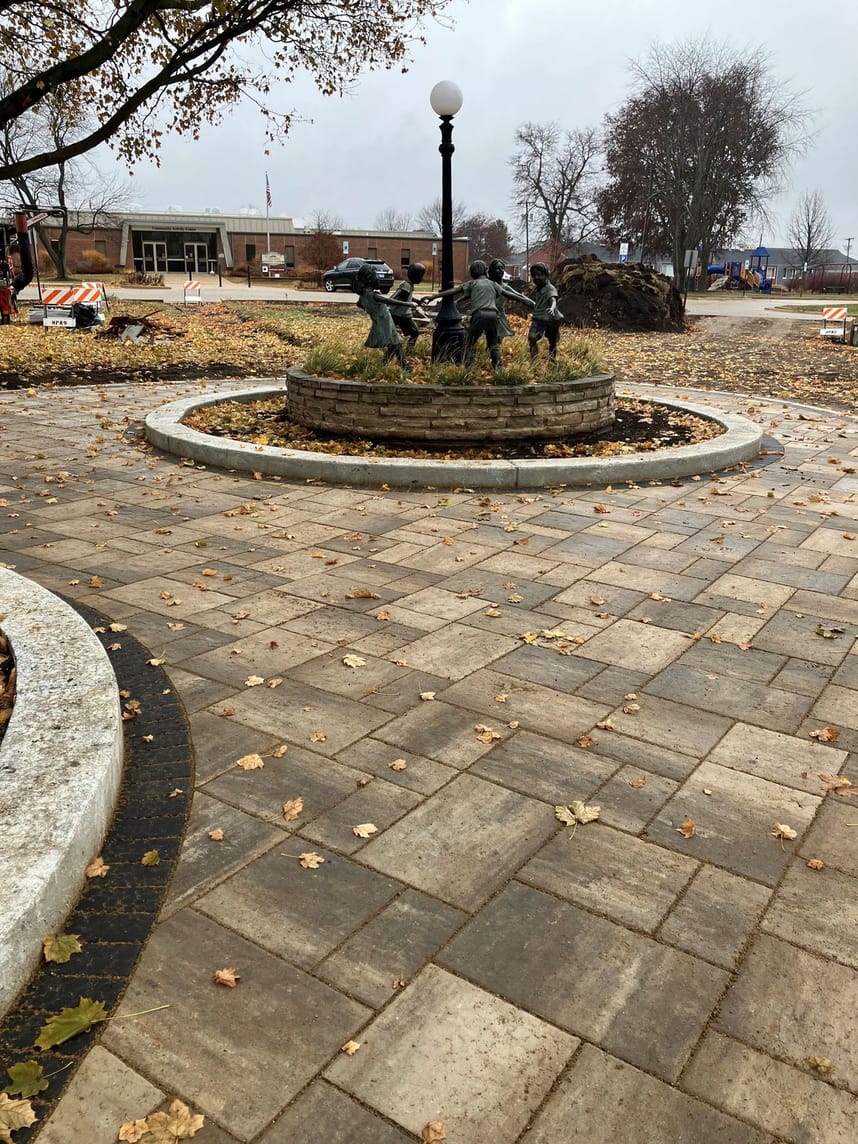 Sculpture of children playing ring around the rosy in a "Circle of Friendship" is surrounded by updated pavement and plaza area.