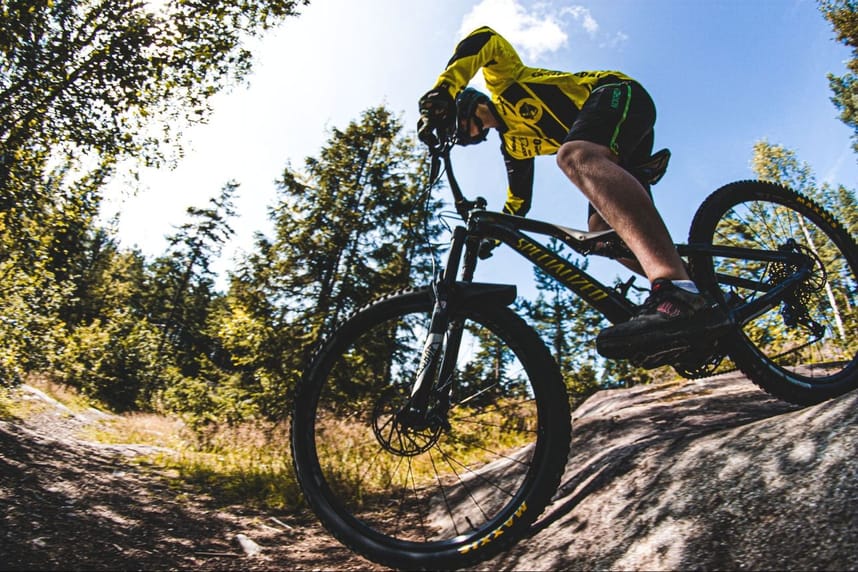 Photo of side view of person riding a mountain bike on the mountain bike trail