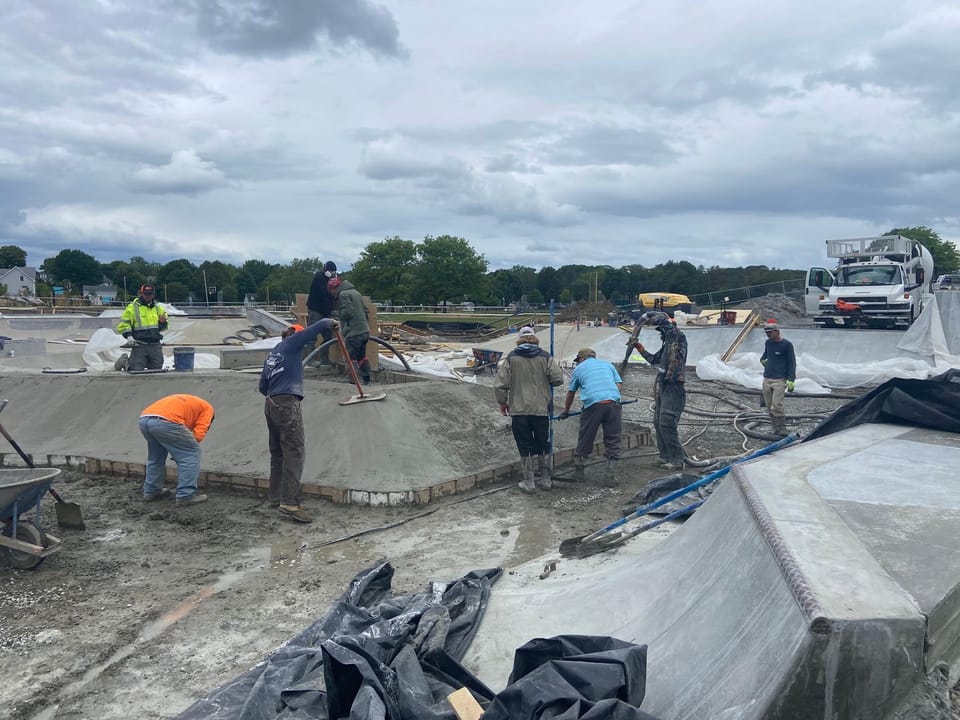 Shotcrete being applied and fresh concrete getting smoothed out with floats immediately