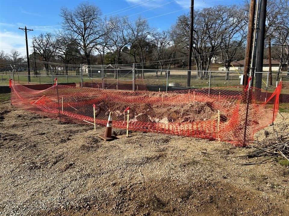 Photo of construction site with orange plastic fencing blocking it off