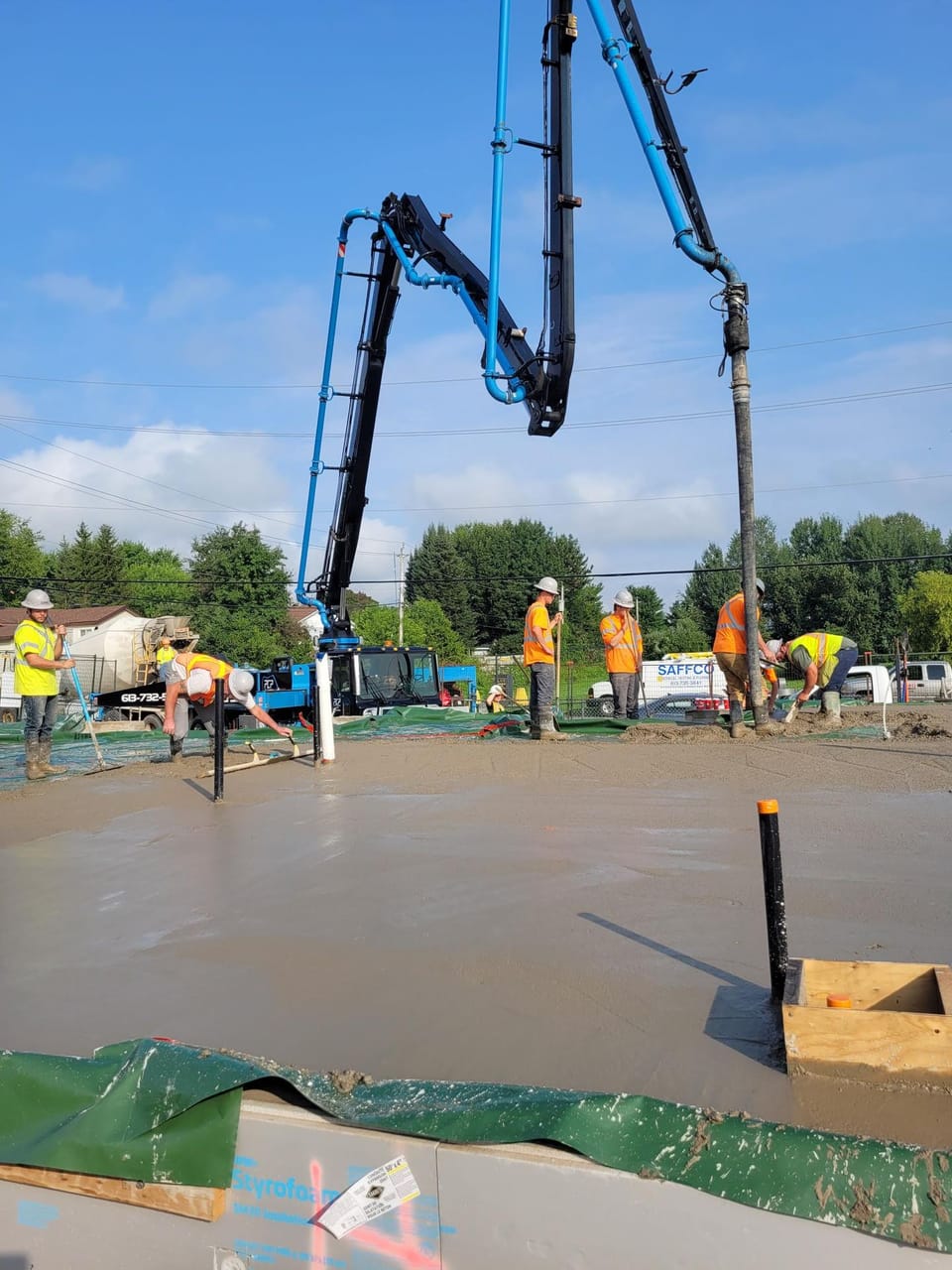 Workers pouring concrete for new build project.