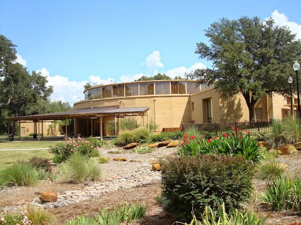 Photo outside of the Civic Center building on the left side with greenery