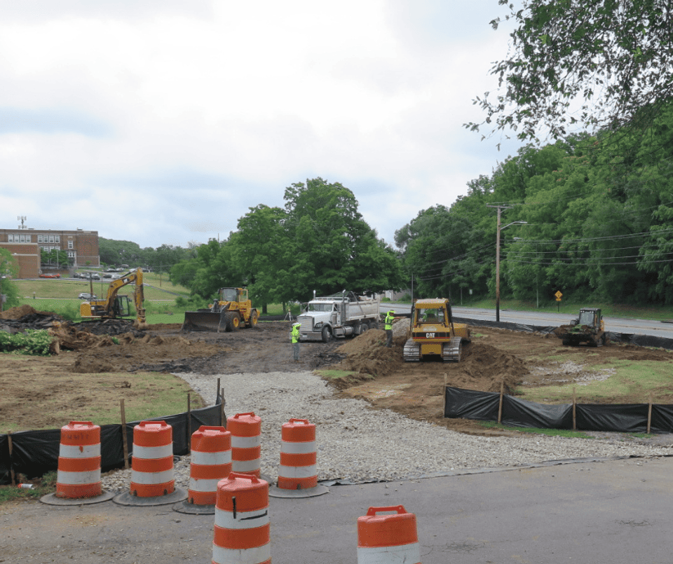Dump trucks removing rubble from tennis courts and moving dirt