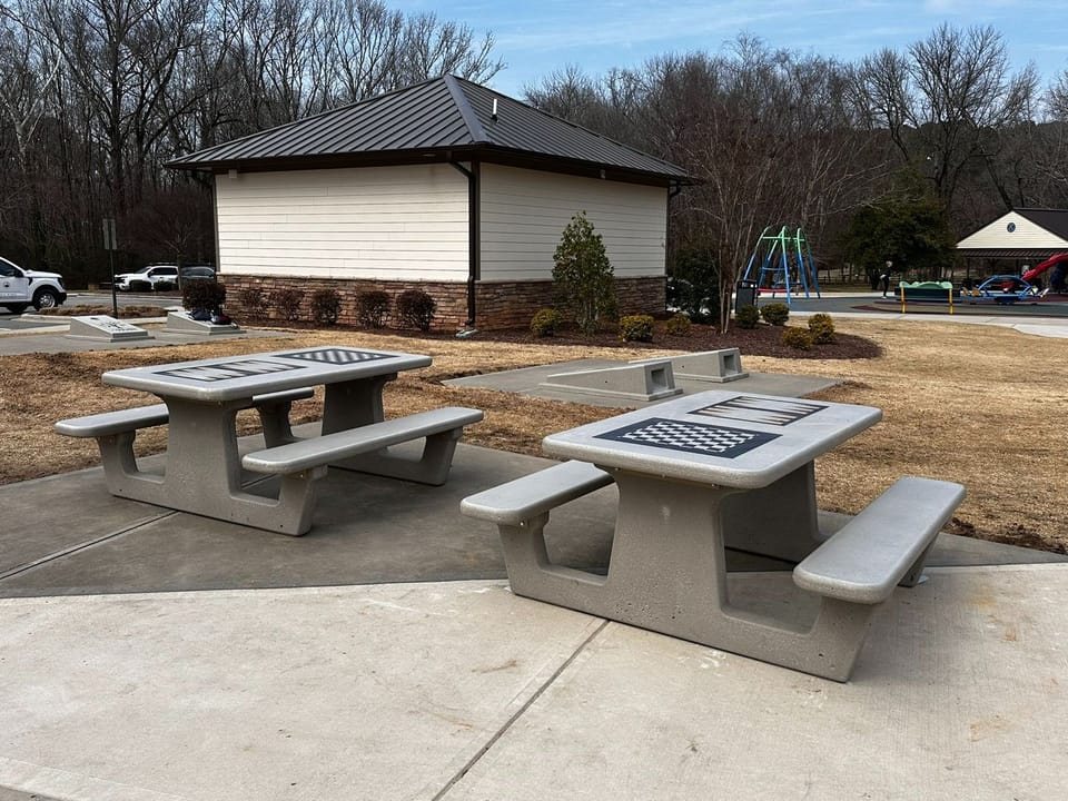 Concrete game tables and cornhole boards at Kiwanis Family Park.