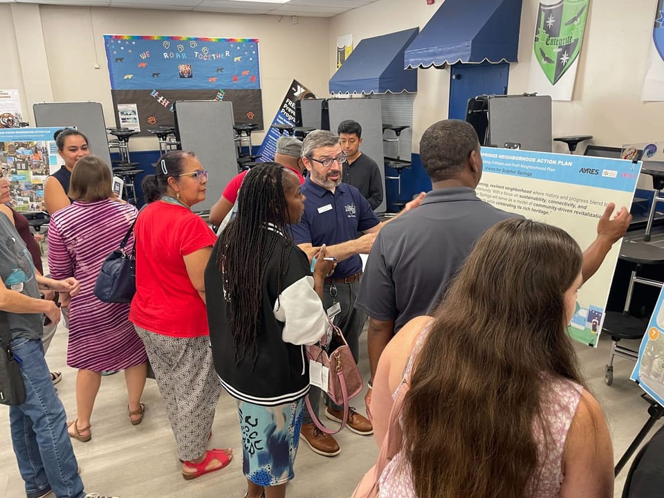 City staff and residents gathered around a board at the phase 2 community workshop