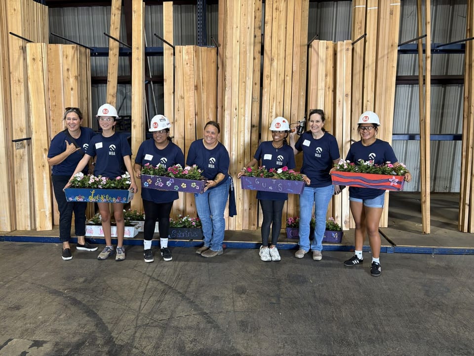 Seven Women from Women Building America with five women holding plants 
