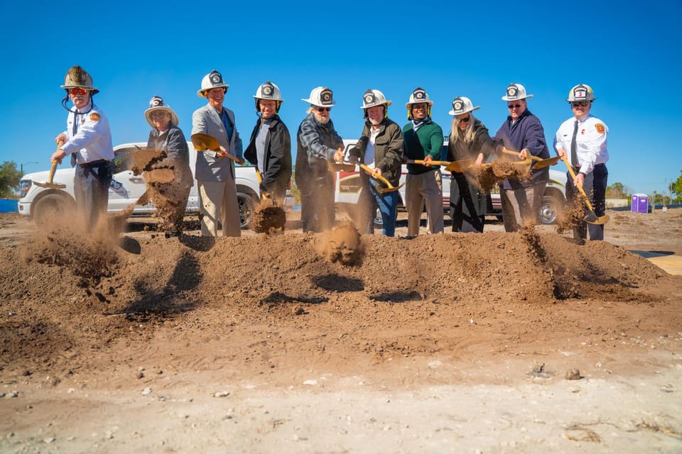 Lineup of people shoveling dirt during a groundbreaking ceremony