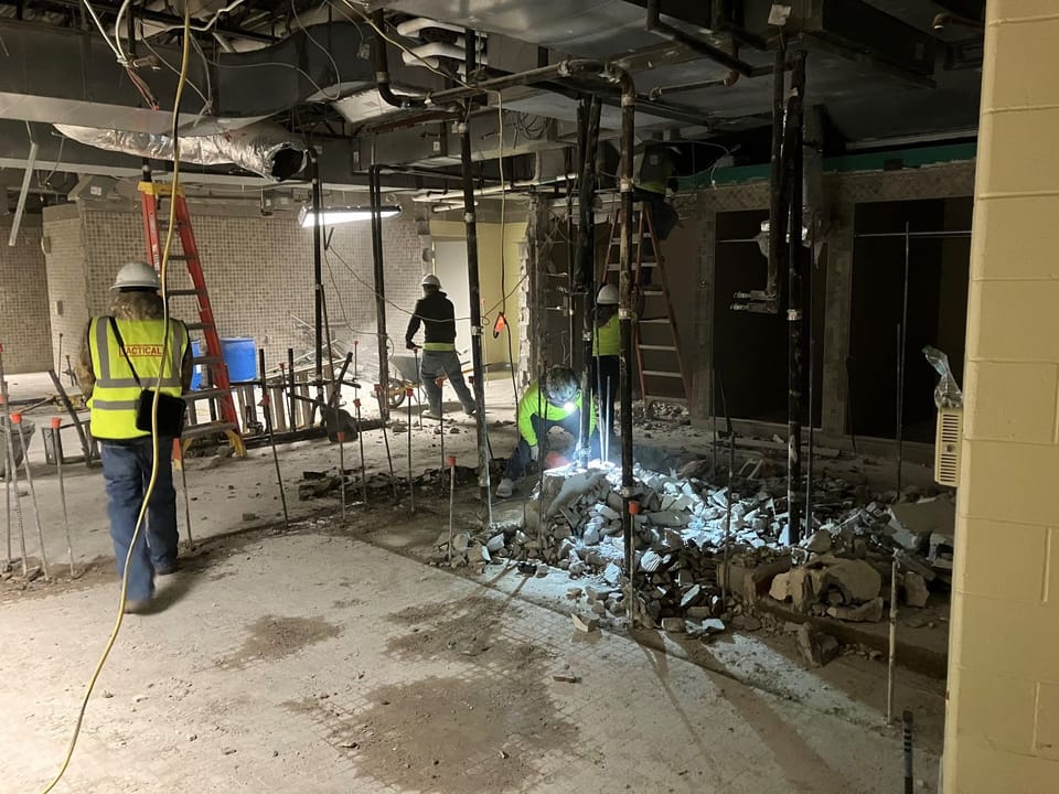 construction workers working in locker room that has been demolished