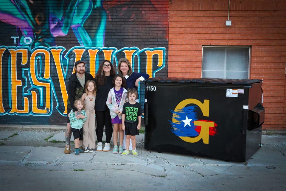 Local artists Ruthie and Charlie Partin with their 3 children and General Services Director Polly Boone, with one of the final dumpsters. 