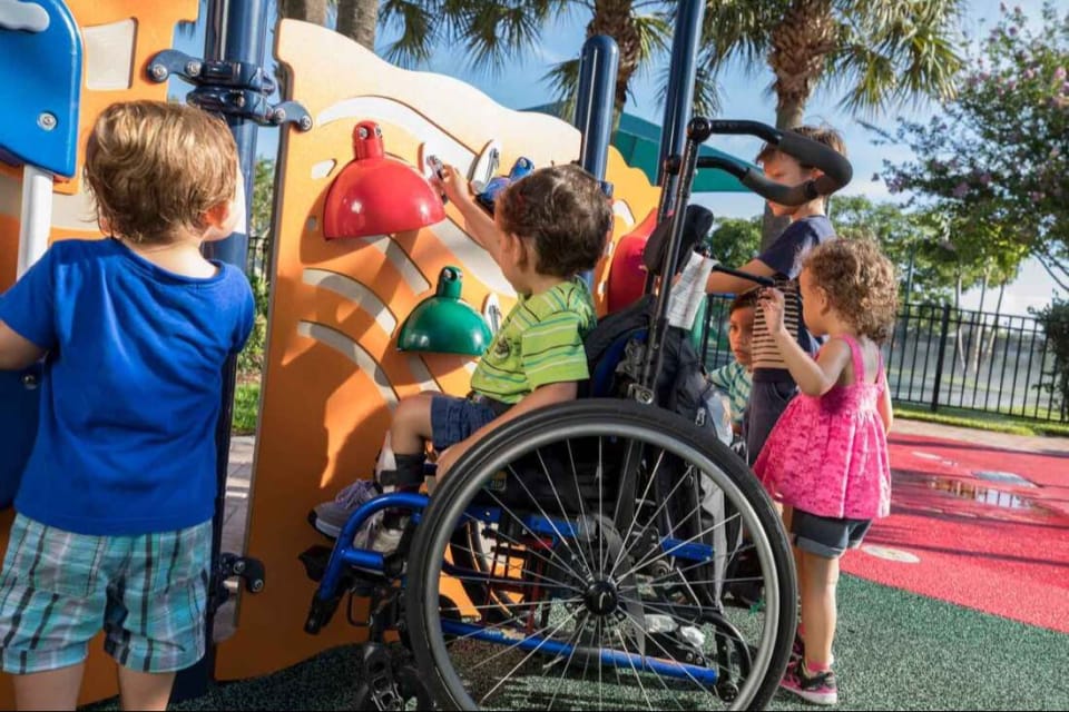 Child in wheel chair playing on playground with other children